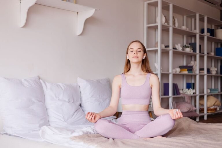 A peaceful woman practicing a 10-minute mindful morning routine at home, sitting calmly in meditation with sunlight streaming in