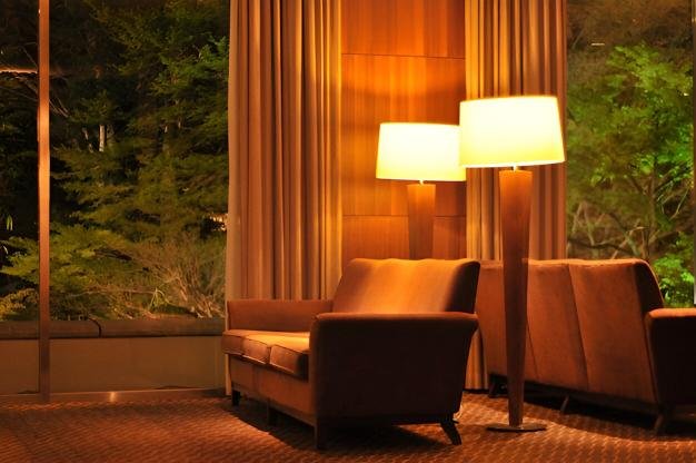 cozy living room warm lights evening A cozy living room with warm amber lights and smart color bulbs enhancing relaxation