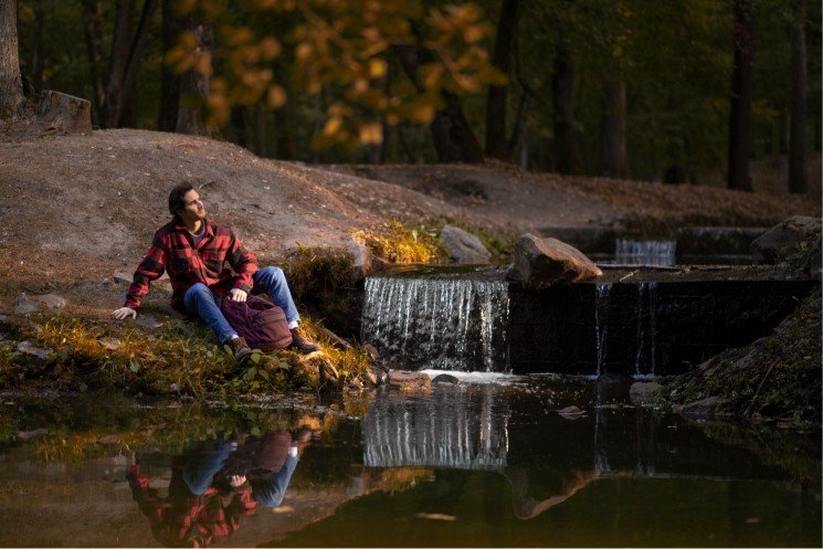 full-shot-man-sitting-by-river Minnesota Solitude: Rediscovering Solitude on the North Shore Scenic Drive