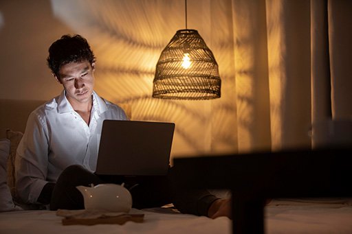 Anonymized sleep log next to a warm bedside lamp, illustrating how tracking and nighttime lighting link together.
